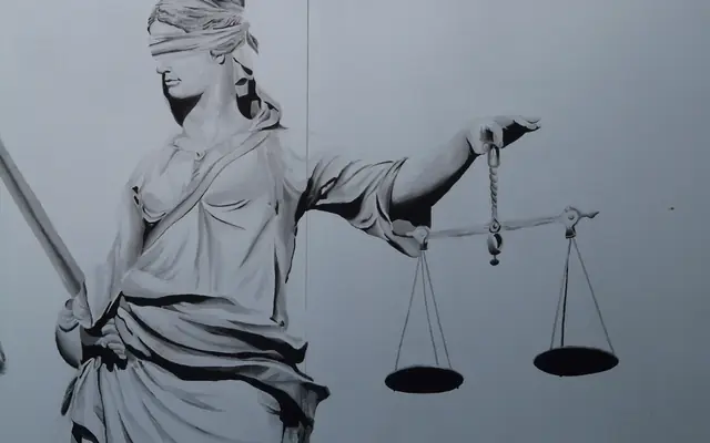 Relieve de la justicia con los ojos vendados sosteniendo una balanza